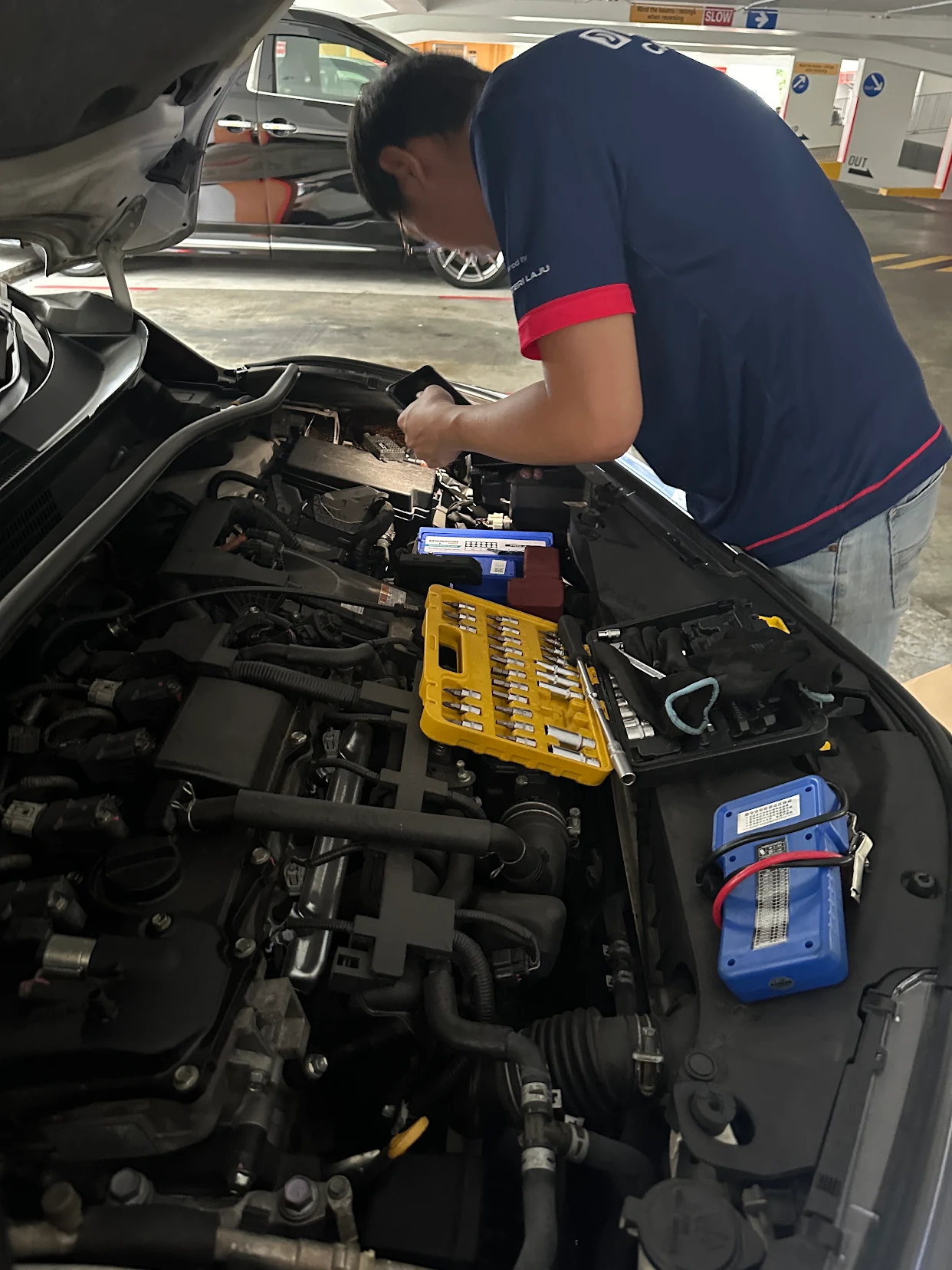 Technician changing a car battery on-site